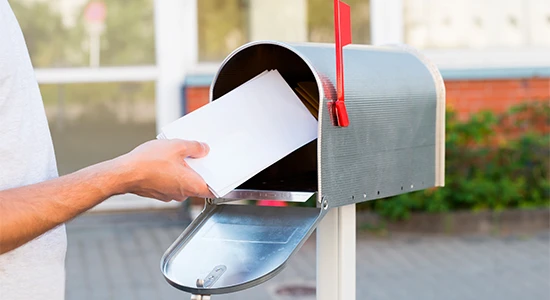 Man putting letters into a mailbox